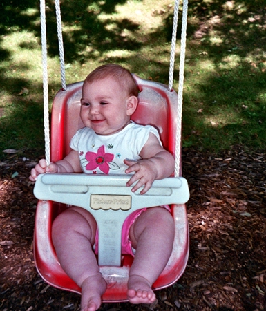 Ella smiling and swinging
