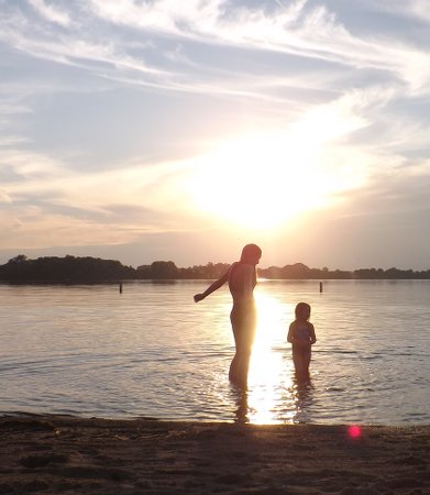 Nora and Ella wading under the setting sun