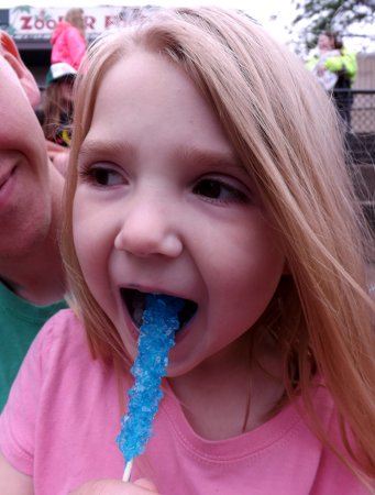 Ella eating a sucker with blue mouth