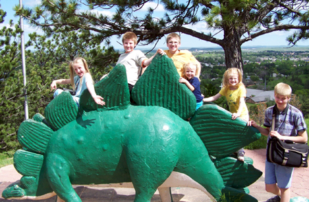 the kids on the back of a spiked dino